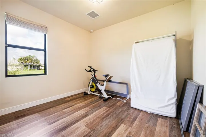 Exercise area featuring wood finished floors and baseboards