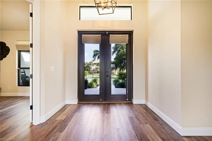 Foyer entrance with french doors, wood finished floors, and baseboards