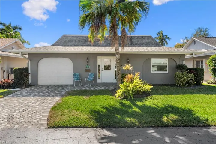Single story home featuring a garage and a front yard