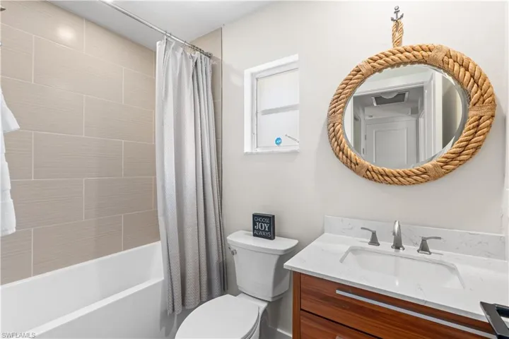 Full bathroom with shower / bath combination with curtain, vanity, and toilet