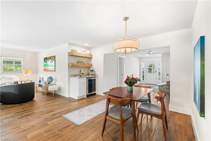 Dining room with a healthy amount of sunlight, wine cooler, and light hardwood / wood-style flooring
