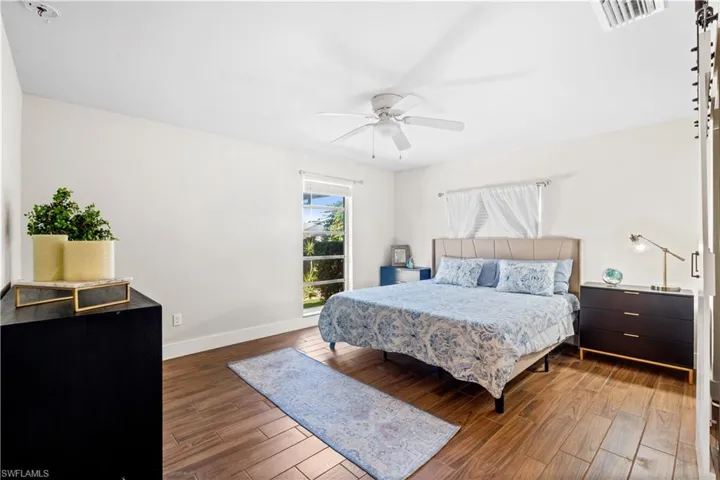 Bedroom with dark hardwood / wood-style flooring and ceiling fan