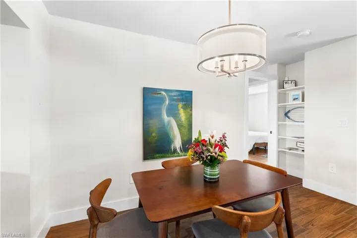 Dining area featuring a notable chandelier and dark wood-type flooring