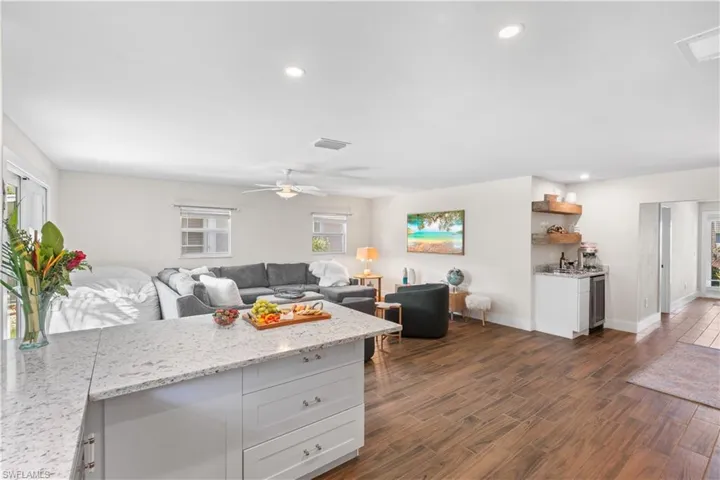 Kitchen with white cabinetry, light stone countertops, and ceiling fan