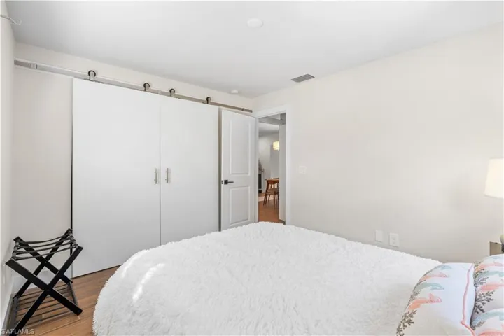 Bedroom with a closet, light hardwood / wood-style flooring, and a barn door