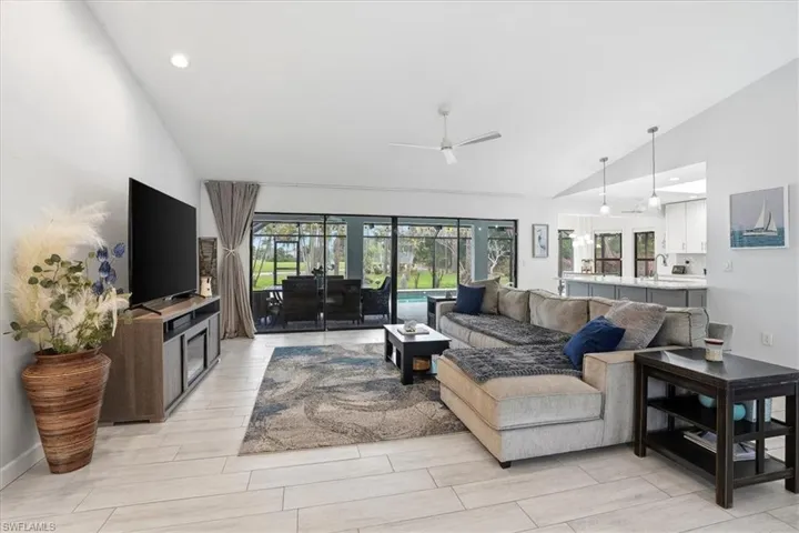 Kitchen with stainless steel appliances, a skylight, light stone countertops, wood tiled floors, and recessed lighting