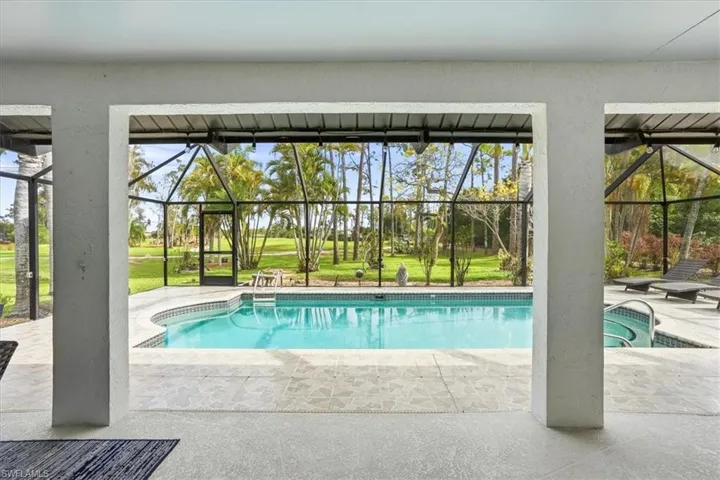 Outdoor pool with a patio, a lanai, a sunroom, and a lawn