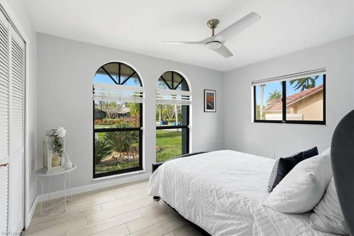 Bedroom with light wood-type flooring, a ceiling fan, and a closet