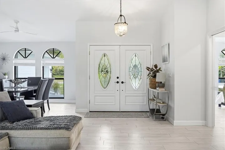 Entrance foyer featuring light wood-style flooring, a chandelier, and a ceiling fan