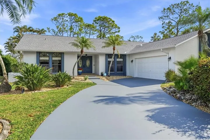 Ranch-style home featuring a front lawn, an attached garage, concrete driveway, and stucco siding