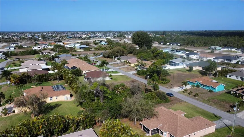 Aerial view of property and surrounding area with nearby suburban area