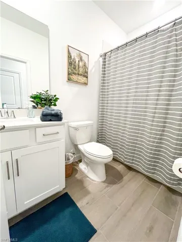 Bathroom with vanity, tile finished floors, and a shower with shower curtain