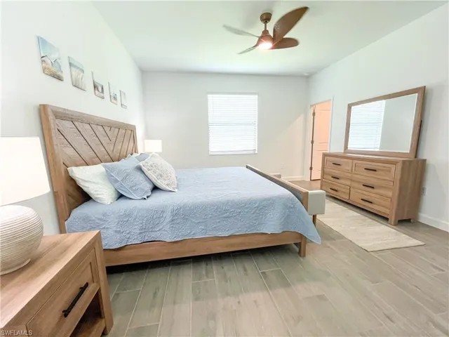 Bedroom featuring light tile finished floors, multiple windows, and ceiling fan