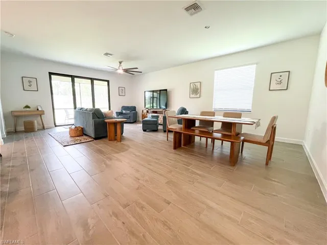 Living area featuring light tile-style floors and a ceiling fan