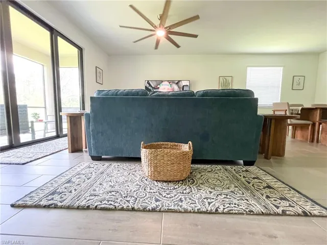 Living area featuring ceiling fan and tile patterned flooring