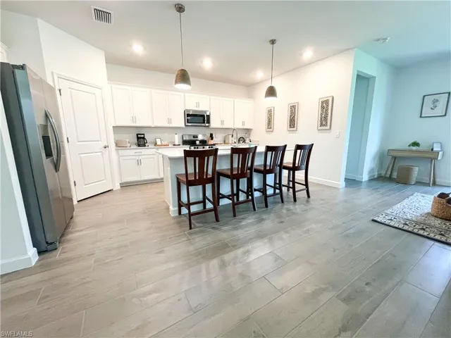 Kitchen with appliances with stainless steel finishes, light tile-style flooring, white cabinetry, light countertops, and recessed lighting