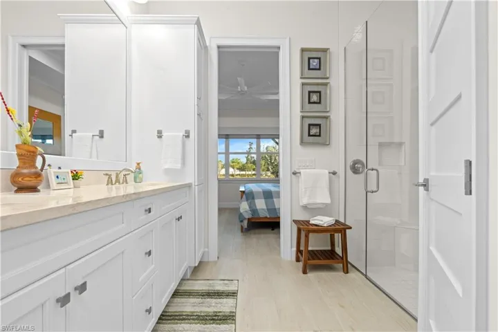 Ensuite bathroom with a shower stall, vanity, and light wood-style flooring