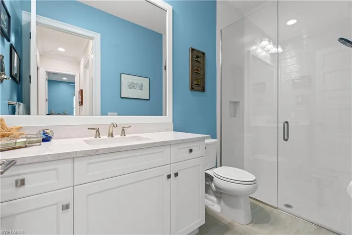 Full bath featuring a stall shower, vanity, light wood-style floors, and recessed lighting
