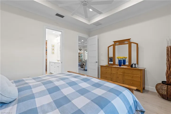 Bedroom featuring light wood-type flooring, a ceiling fan, recessed lighting, ensuite bathroom, and ornamental molding