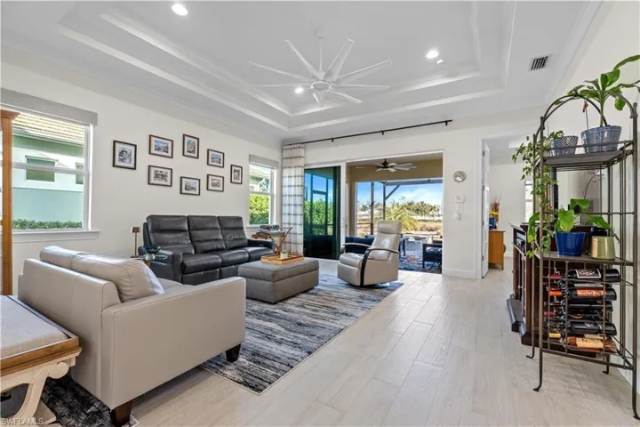 Living area featuring light wood-type flooring, a ceiling fan, recessed lighting, and crown molding