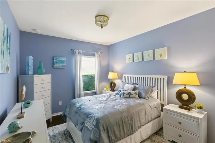 Bedroom with wood finished floors and baseboards