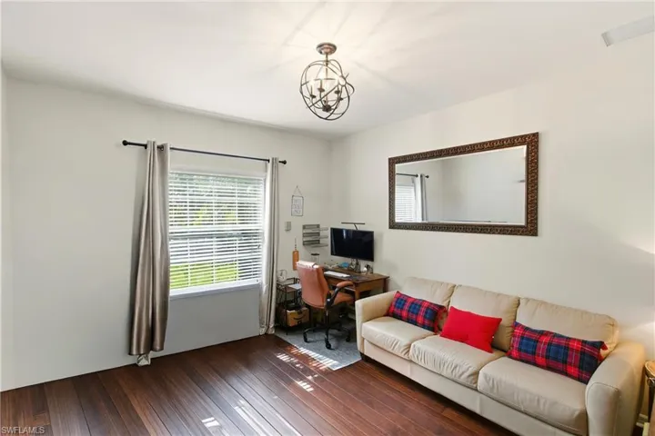 Home office with wood-style tile floors and a chandelier/bedroom