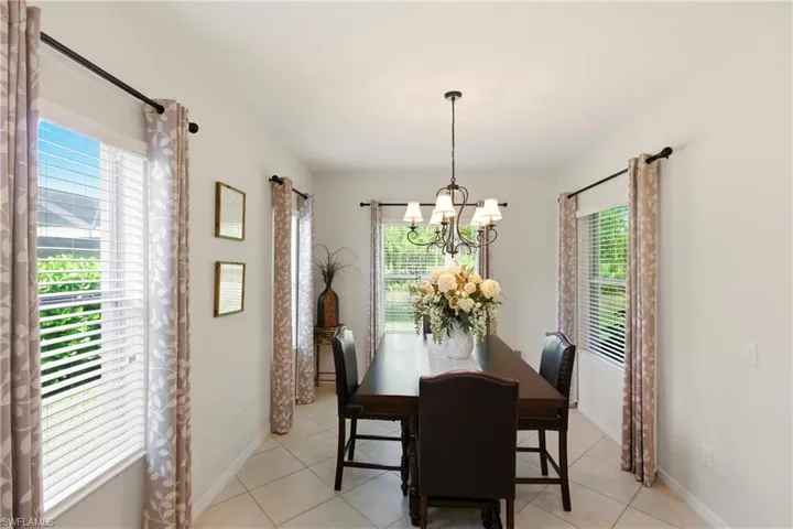 Dining area with healthy amount of natural light, light tile diagonal floors, and a chandelier
