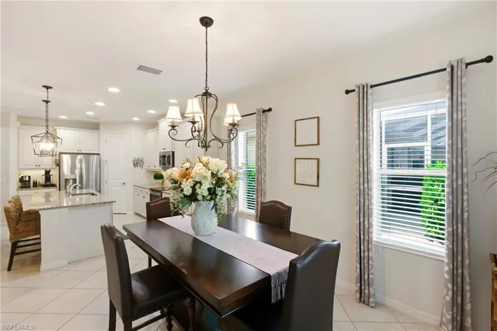 Dining room with a chandelier, light tile diagonal floors, and recessed lighting