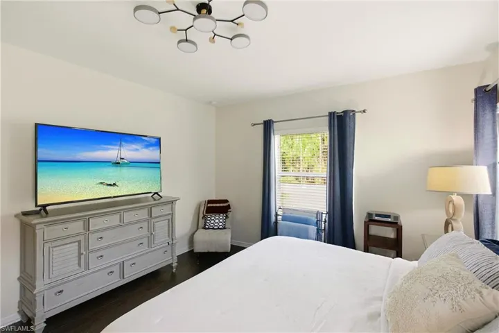 Bedroom featuring dark wood finished floors and a chandelier
