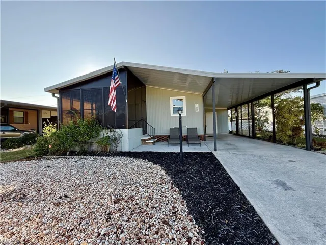 View of front of property with a carport and a sunroom
