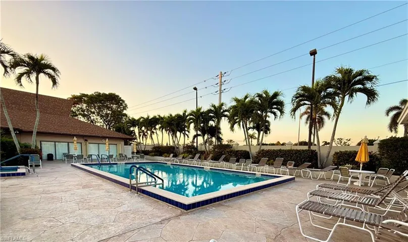 Pool at dusk featuring a patio