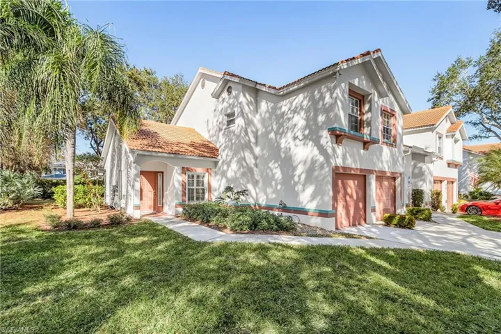 Mediterranean / spanish house featuring stucco siding, a tiled roof, a front yard, and a garage