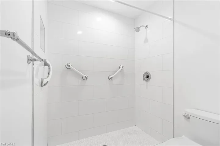 Bathroom featuring tiled shower and toilet