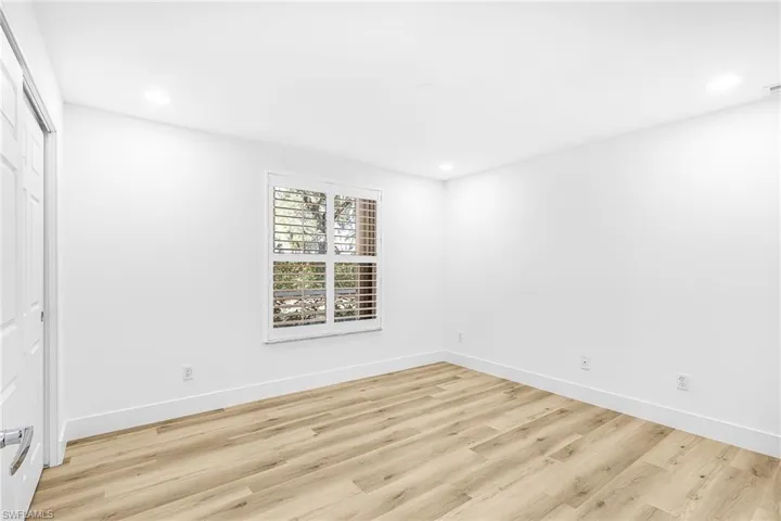 Unfurnished bedroom featuring light wood-type flooring, a closet, and recessed lighting