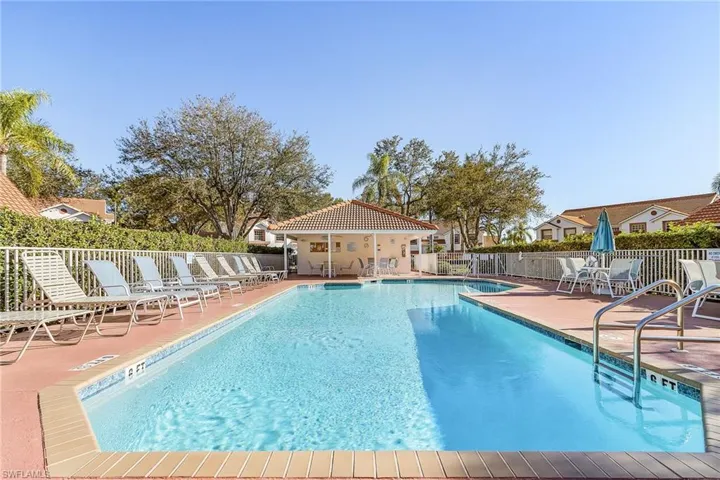 Community pool with a patio area and a residential view