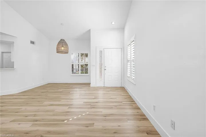 Entryway with light wood-type flooring, healthy amount of natural light, recessed lighting, and lofted ceiling