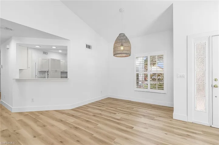 Unfurnished dining area with light wood-style flooring, a chandelier, recessed lighting, and high vaulted ceiling