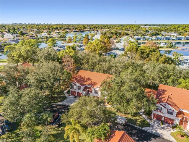 Aerial view of residential area featuring a tree filled landscape and a large body of water
