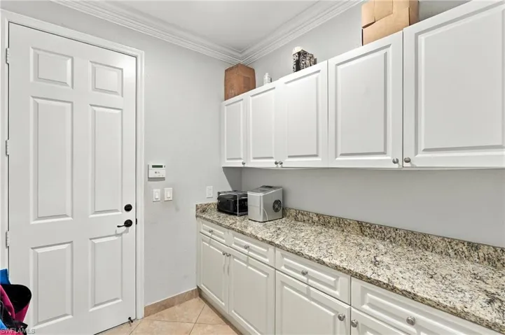 Room with extensive cabinetry and counter workspace leading to the garage.