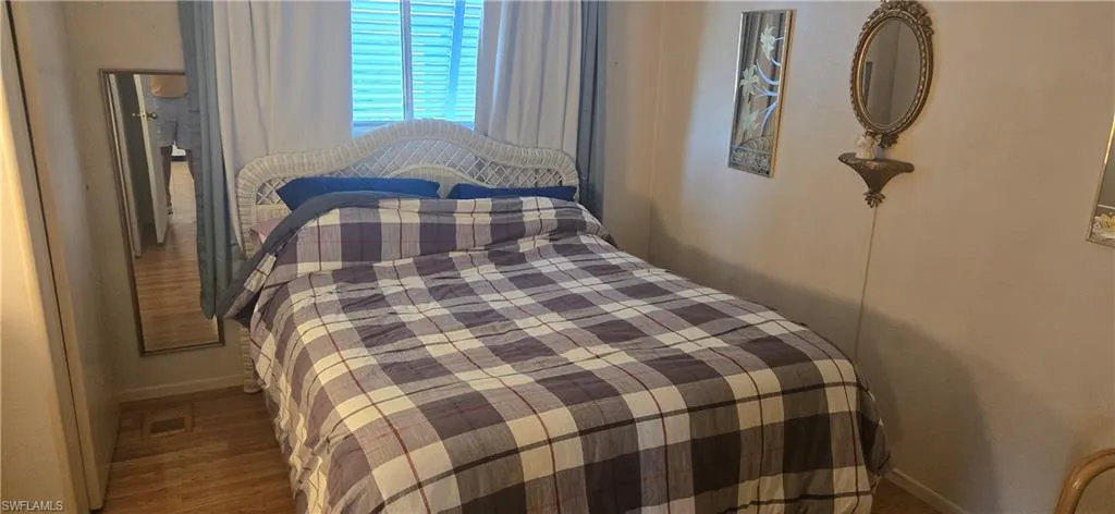 Bedroom with wood finished floors and baseboards