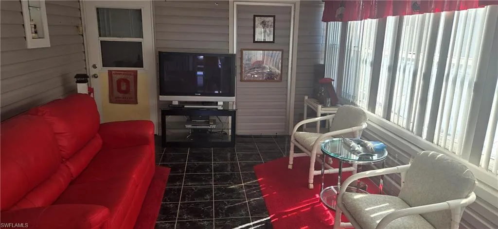 Living area with wood walls and dark tile patterned flooring