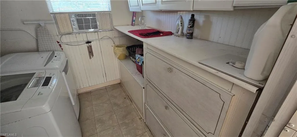 Laundry area featuring washer and clothes dryer, light tile patterned floors, and cooling unit