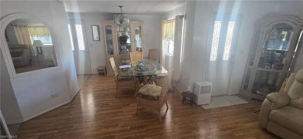 Dining space featuring wood finished floors, plenty of natural light, and a chandelier
