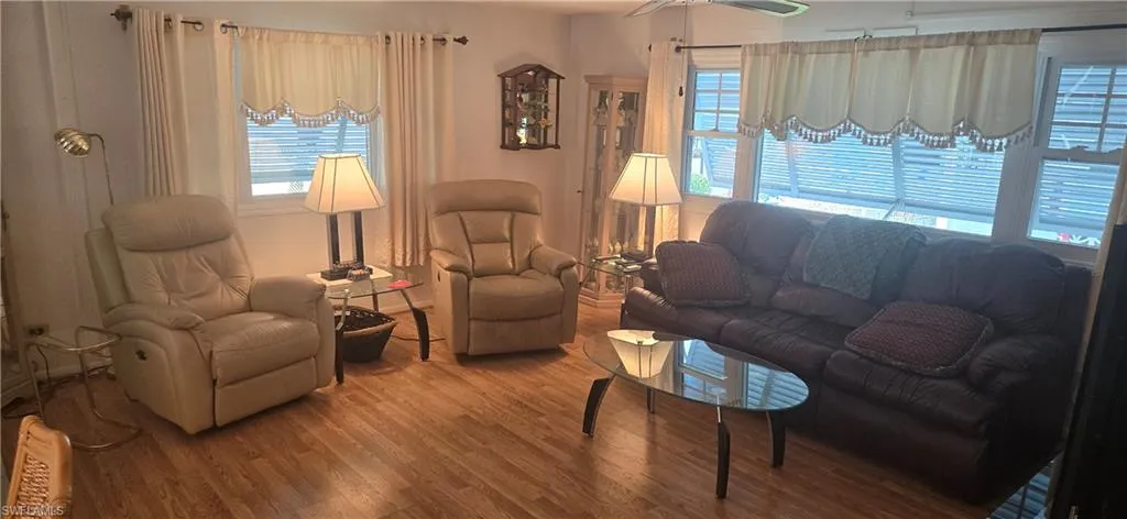 Living area with healthy amount of natural light and wood finished floors