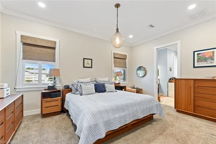 Bedroom with light carpet, crown molding, recessed lighting, and baseboards