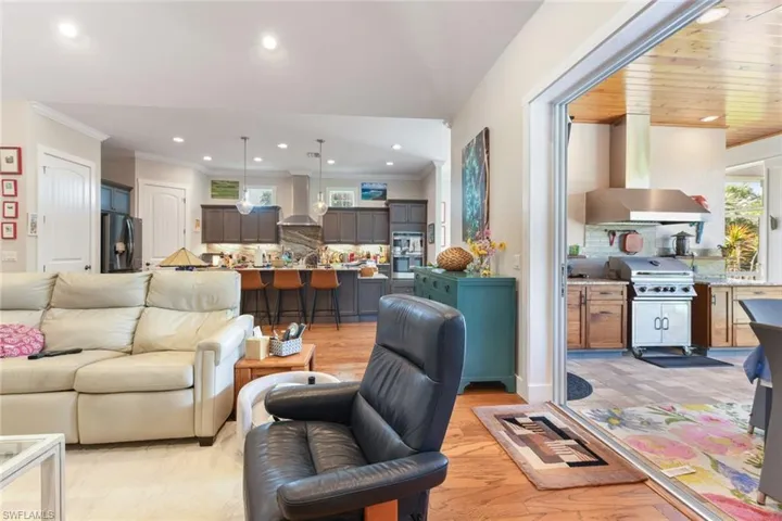 Living area with crown molding, recessed lighting, light wood-type flooring, and lofted ceiling