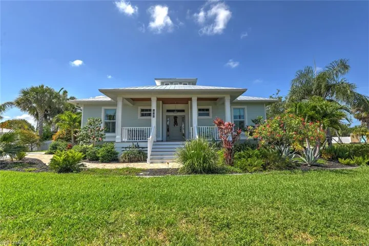 Bungalow-style house featuring a porch, a front yard, a standing seam roof, and metal roof