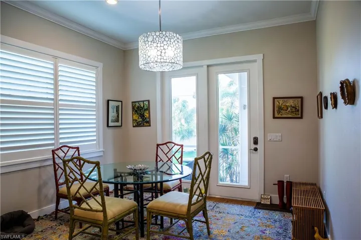 Dining space featuring plenty of natural light, wood finished floors, ornamental molding, a chandelier, and baseboards