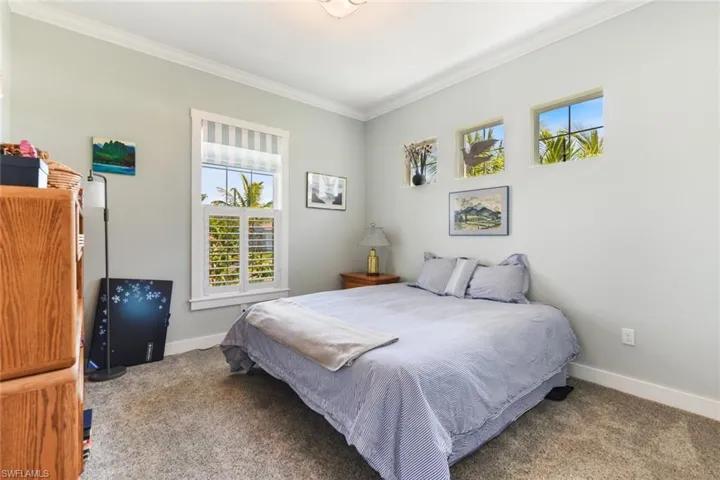 Bedroom featuring carpet floors, ornamental molding, and baseboards