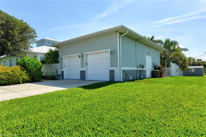 View of side of property featuring concrete driveway and a garage